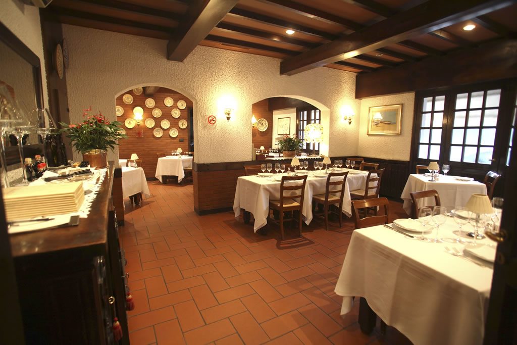 Parete decorata con piatti in ceramica e bottiglie di vino
