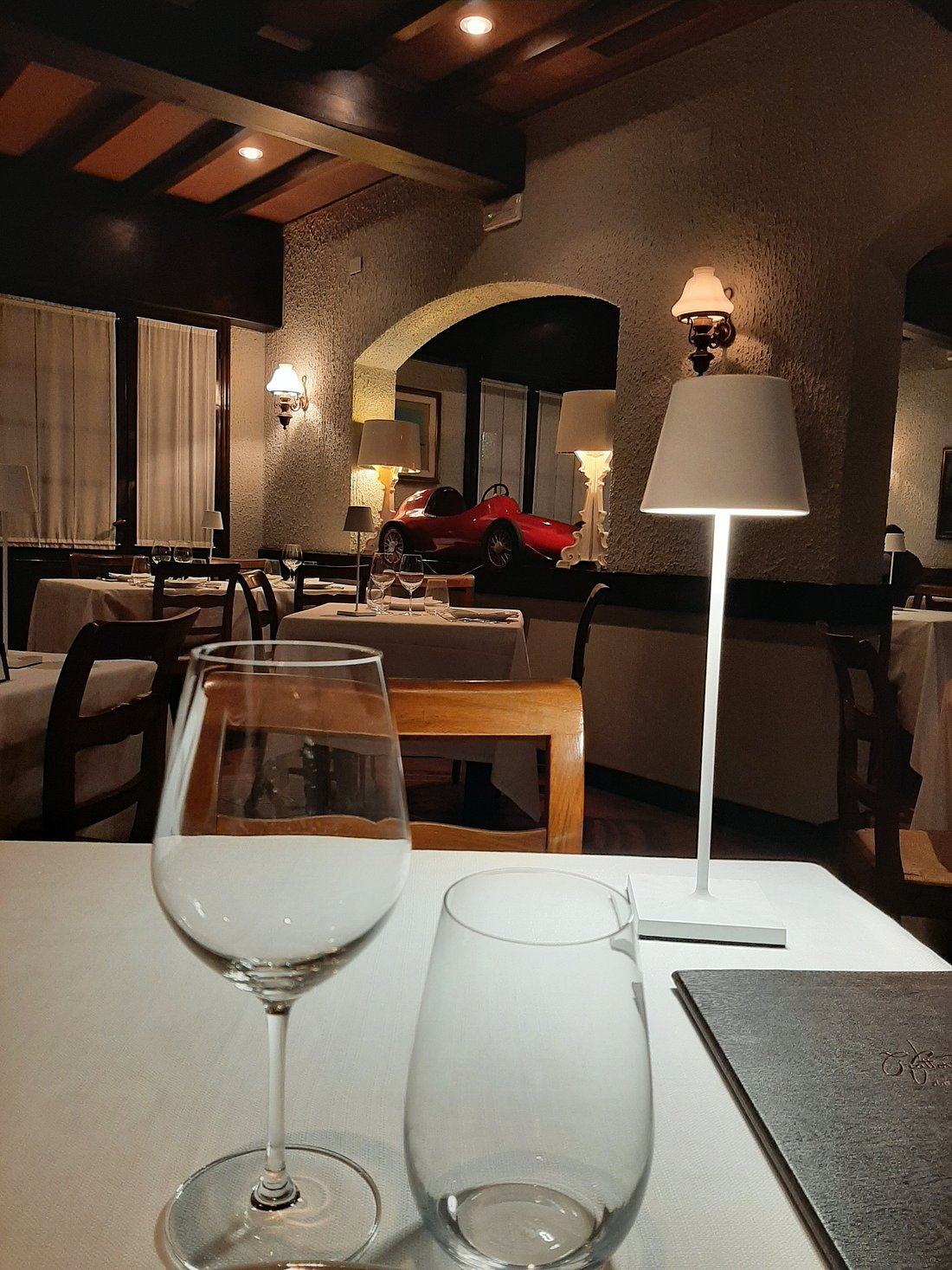 Sala da pranzo con tavoli apparecchiati e lampada da tavolo